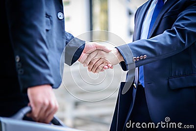 Two asian business have handshake with building and city background. Stock Photo