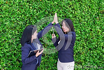 Two asian businesswoman high five for business success outside o Stock Photo