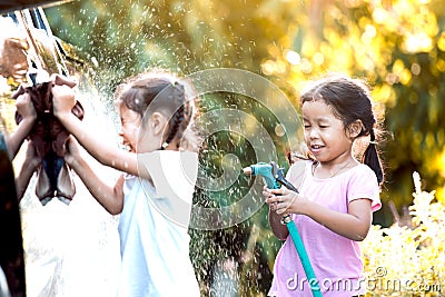 Two asian child girls having fun to help parent washing car Stock Photo