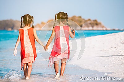 Two asian child girls holding hand each other and walking together on beach near the sea in summer vacation Stock Photo