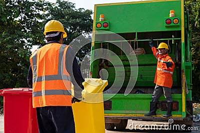 Two Asian Garbage men working together on emptying dustbins for trash removal. Garbage collector Stock Photo