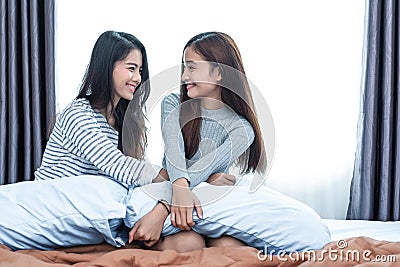 Two Asian Lesbian women in bedroom. Couple people and Beauty concept. Happy lifestyles and home sweet home theme. Cushion pillow Stock Photo