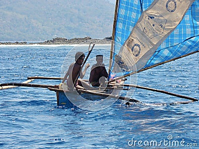 Two Asians fishermen on an island in East Nusa Tenggara, sailed across the Pantar Strait in a small canoe and sail Editorial Stock Photo
