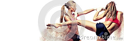 Two attractive athletic girls fighting, standing on defence pose image with digital effects sandy fragments. Stock Photo