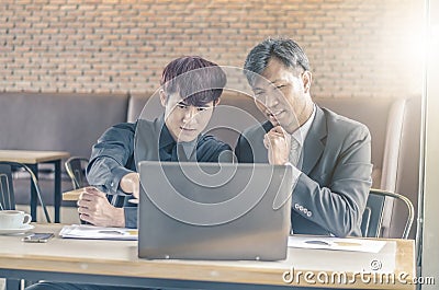 Two attractive businessmen having a meeting with laptop while having coffee Stock Photo