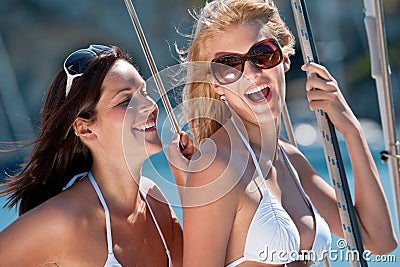 Two attractive smiling woman on sailboat Stock Photo