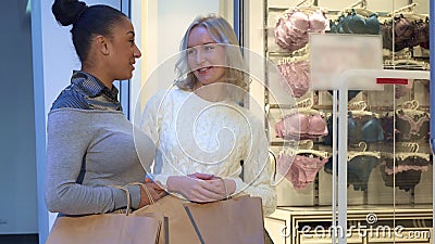 Women discuss bras and panties near the lingerie shop Stock Photo