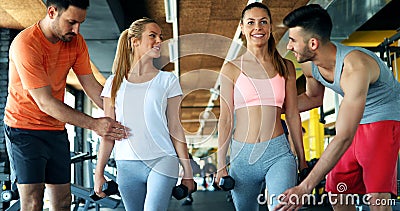 Two attractive women exercising with personal trainers Stock Photo
