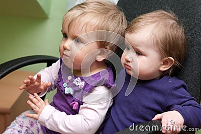 Two baby girls in chair Stock Photo