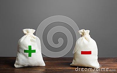 Two bags with green plus red minus. Summary and balance sheet. Income and expenses. Trade balance budgeting. Financial management Stock Photo