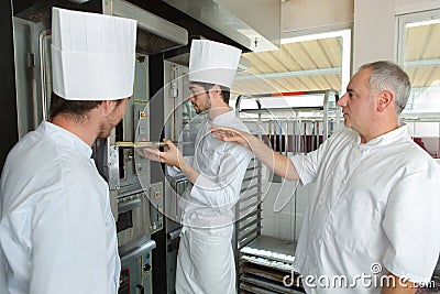 Two bakers in bakery or bakehouse baking pretzels Stock Photo
