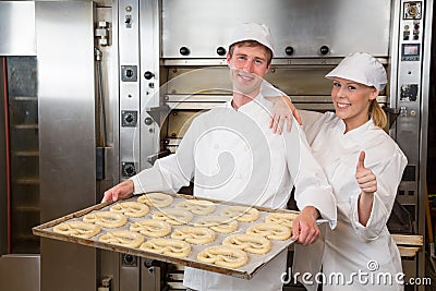 Two bakers with griddle full of pretzels Stock Photo