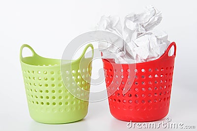 Two baskets. The green basket is empty - the red one is full. Crumpled paper in the trash can Stock Photo
