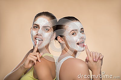 Two beautiful girls applying facial cream mask and Stock Photo
