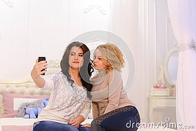 Two beautiful girls make selfie photo, using gadget, for memory, Stock Photo