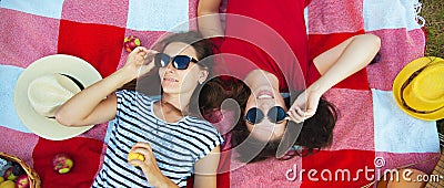 Two beautiful girls in sunglasses having fun on a picnic in the forest Stock Photo