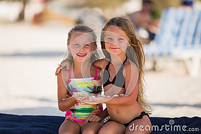 Two beautiful happy girl with shells in their hands Stock Photo