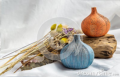 Two beautiful small ceramic vases with wooden logs on white background Stock Photo
