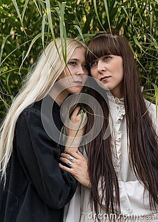 Two beautiful twin girls make style in nature, sunset Stock Photo