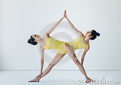 Two beautiful women doing yoga asana extended triangle pose Stock Photo