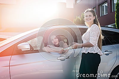 Two beautiful women exchanging by dollars and car keys Stock Photo