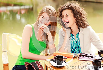 Two beautiful women laughing over a cofee Stock Photo