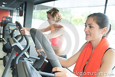 Two beautiful young girls exercising together in gym Stock Photo