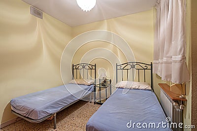 Two beds in a small simple bedroom in a hostel, motel or guest house. Concept of budget accommodation for rent or travel Stock Photo