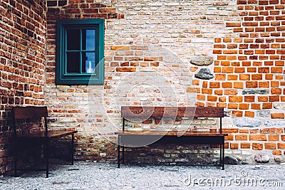 Two benches standing in front of old building with green window. Stock Photo