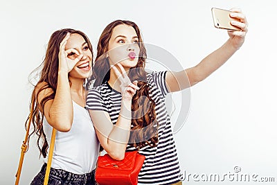 Two best friends teenage girls together having fun, posing emotional on white background, besties happy smiling Stock Photo