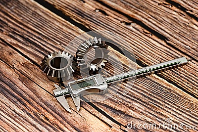 Two bevel gears and vernier caliper on a wooden background Stock Photo