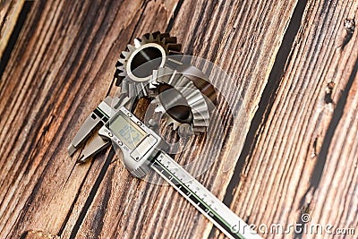 Two bevel gears and vernier caliper on a wooden background Stock Photo