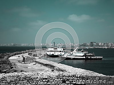 Two Big Fish boats parking next to the walls of the Citadel of Qaitbay on the coast of Alexanderia, Egypt Editorial Stock Photo