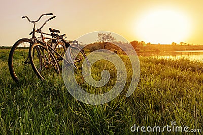 Two bike near the lake sunset background. Two vintage bicycles at sunset. The concept of romance and love Stock Photo