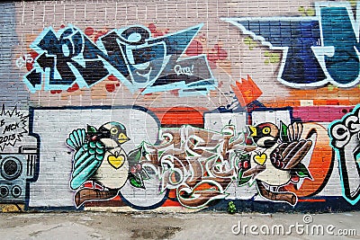 Two birds painted on a brick wall. Editorial Stock Photo