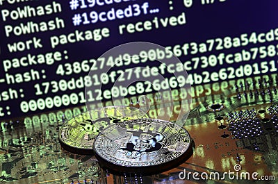 Two bitcoins lies on a videocard surface with background of screen display of cryptocurrency mining by using the GPUs Stock Photo
