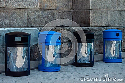 Two black garbage bins and two blue recycle bins. Public trash waste cans Stock Photo