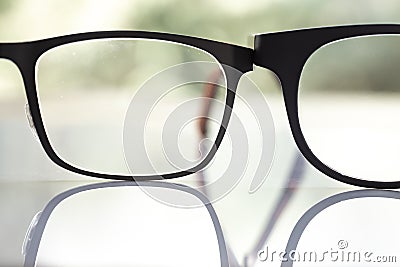 Two black shortsighted or nearsighted eyeglasses on white acrylic table, Bokeh green garden background, Close up & Macro shot Stock Photo
