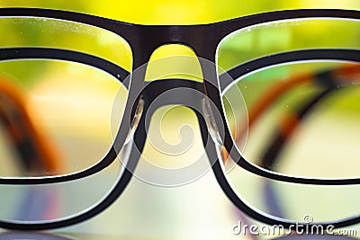 Two black shortsighted or nearsighted eyeglasses on white acrylic table, Bokeh green garden background, Reflection, Optical Stock Photo