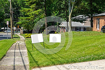 Two blank white signs on a green grassy lawn in a residential community Stock Photo