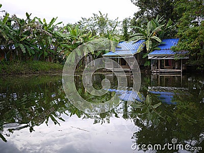 two blue color roof huts near the reflection clear water pond Stock Photo