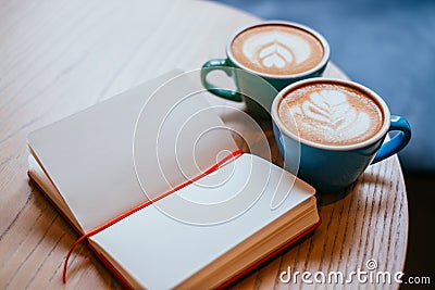 Two cups of cappuccino with notebook Stock Photo