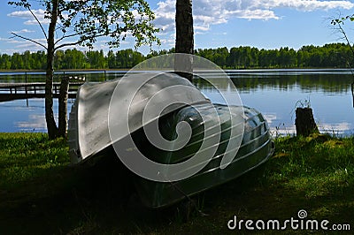 Two boats overturned on the shore of the lake Stock Photo