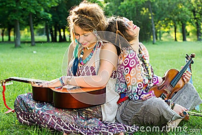 Two Bohemian Musicians sitting on the grass Stock Photo