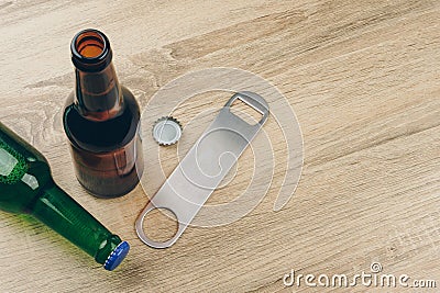 Two bottles of beer and a stainless steel bottle opener Stock Photo