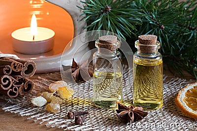 Two bottles of essential oil with cinnamon, star anise, frankinc Stock Photo