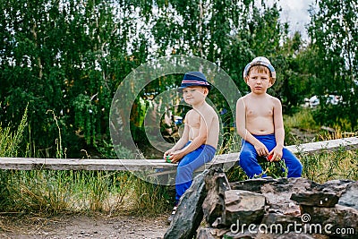 Two boys in blue pants and hats Stock Photo