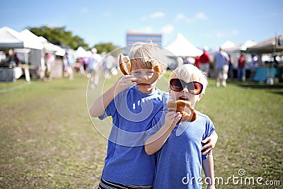 Two boys Having Fun Eating Pretzles at Farmer`s Market Stock Photo