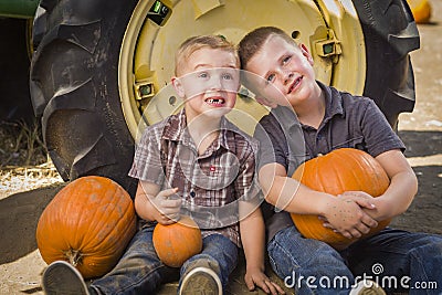 Two Boys Having Fun at the Pumpkin Patch on a Fall Day Stock Photo
