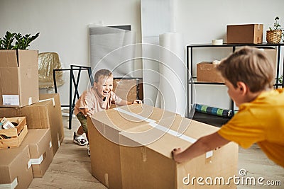 Two Boys Moving Boxes in New House Stock Photo